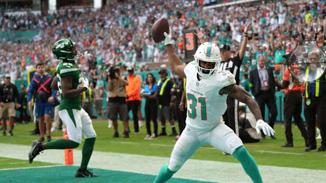 Miami Dolphins running back Raheem Mostert (31) spikes the ball after scoring a touchdown past New York Jets safety Tony Adams (22) during the first half of an NFL game at Hard Rock Stadium in Miami Gardens, Dec. 17, 2023.